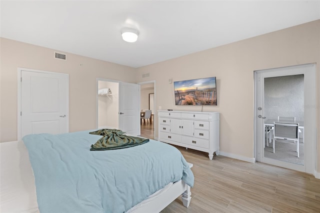 bedroom featuring light wood-style floors and baseboards