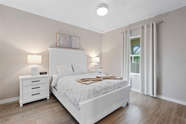 bedroom featuring light wood-type flooring and baseboards
