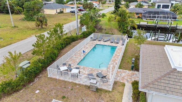aerial perspective of suburban area featuring a pool area and a large body of water