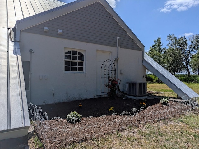 view of property exterior with a standing seam roof and central AC unit