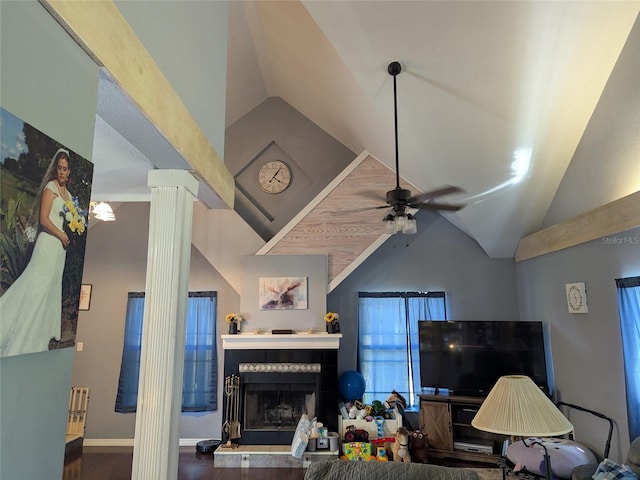 living room featuring vaulted ceiling, a ceiling fan, decorative columns, and a fireplace