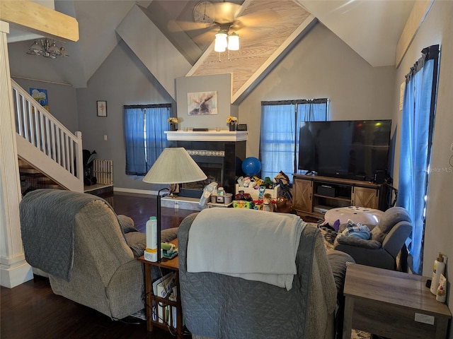 living area with ceiling fan, stairs, wood finished floors, lofted ceiling, and a tile fireplace