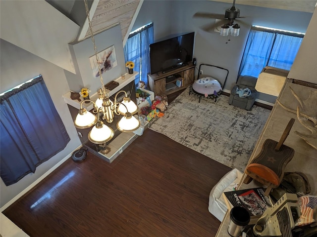 living area with baseboards, ceiling fan with notable chandelier, and wood finished floors