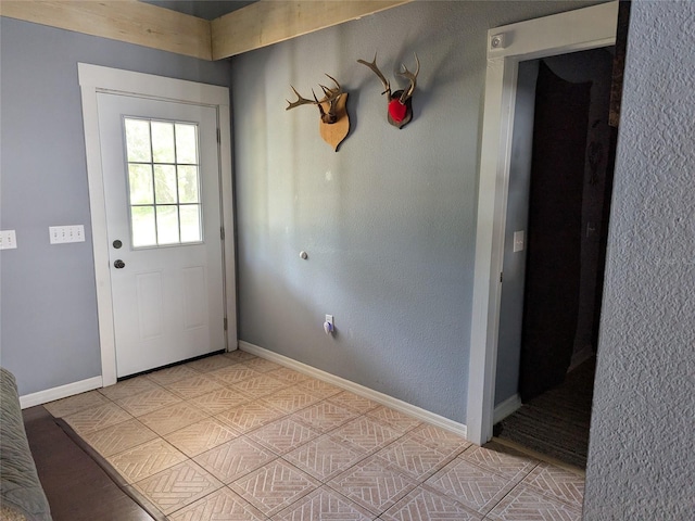 doorway featuring baseboards