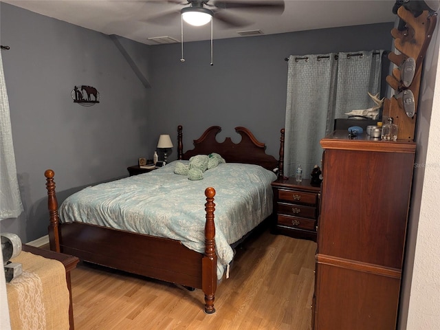 bedroom featuring ceiling fan, wood finished floors, and visible vents