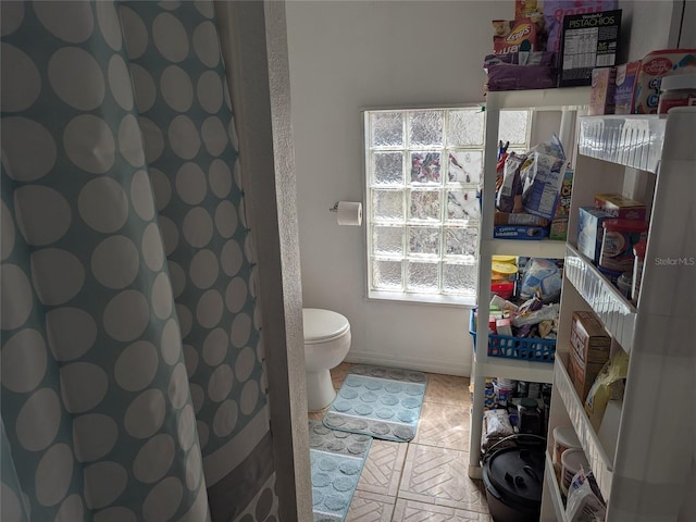 bathroom with baseboards and toilet