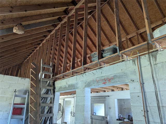 miscellaneous room featuring concrete block wall and lofted ceiling