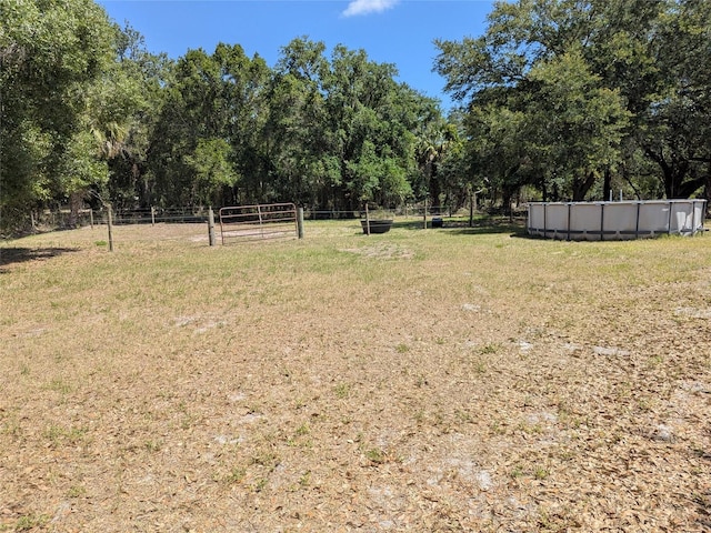 view of yard featuring an outdoor pool and fence