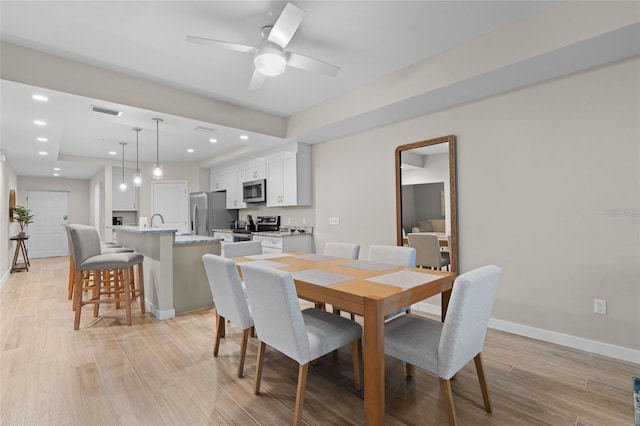 dining area with light wood-type flooring, baseboards, a ceiling fan, and recessed lighting