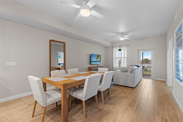 dining area with a ceiling fan, light wood-style flooring, and baseboards