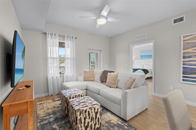 living area featuring wood finished floors, ceiling fan, and baseboards