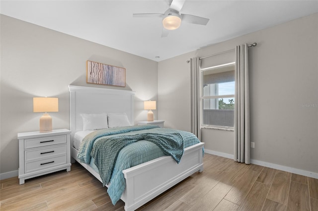 bedroom featuring light wood finished floors, baseboards, and ceiling fan