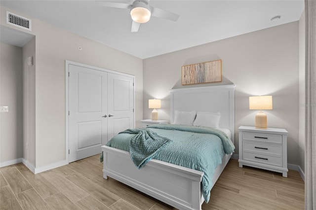 bedroom featuring a closet, baseboards, light wood finished floors, and ceiling fan
