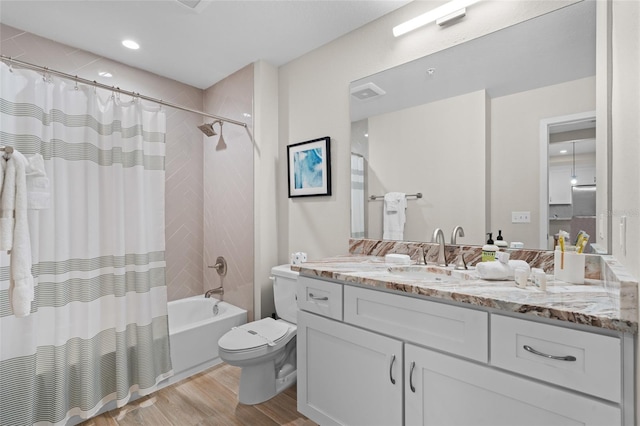 full bath with wood finished floors, toilet, shower / tub combo with curtain, and vanity