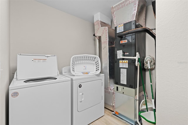 laundry area featuring washer and dryer and wood finished floors