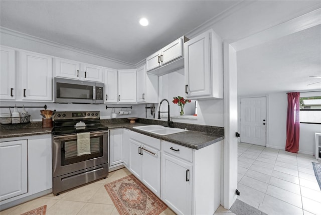 1741 NE Trisha Dr, Arcadia, FL 34266 - kitchen with appliances with stainless steel finishes, a sink, light tile patterned floors, dark countertops, and white cabinets
