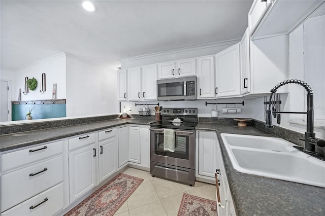 1741 NE Trisha Dr, Arcadia, FL 34266 - kitchen featuring appliances with stainless steel finishes, a sink, ornamental molding, white cabinets, and light tile patterned floors