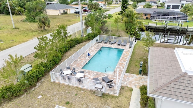 community pool featuring fence, a residential view, a water view, and a patio area