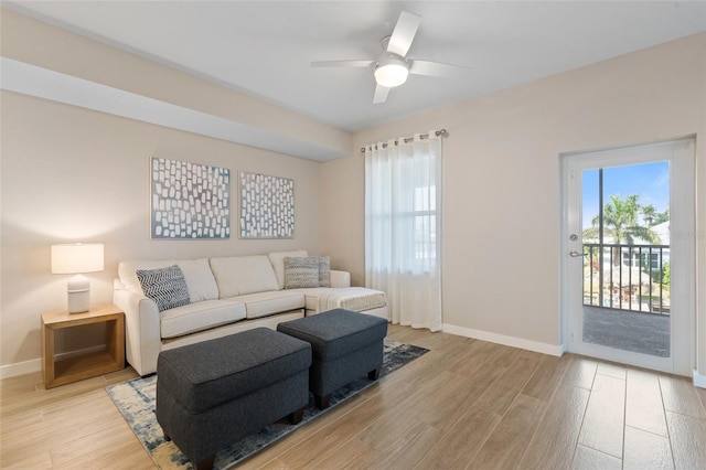 living room with wood finished floors, baseboards, and healthy amount of natural light