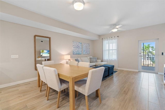 dining area with light wood-type flooring, baseboards, and ceiling fan