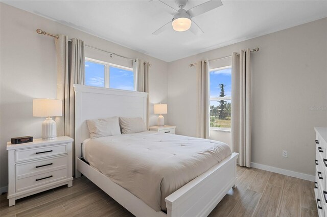 bedroom featuring light wood-style flooring, ceiling fan, and baseboards