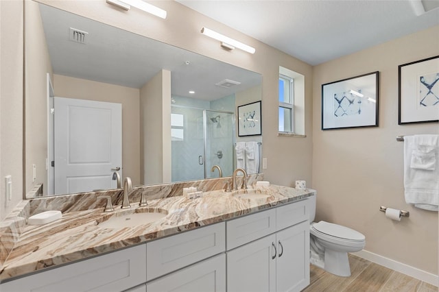bathroom featuring wood finished floors, toilet, plenty of natural light, and baseboards