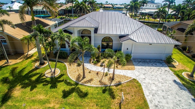 3520 Caya Largo Ct, Punta Gorda, FL 33950 - view of front of property with driveway, metal roof, a front yard, a garage, and stucco siding