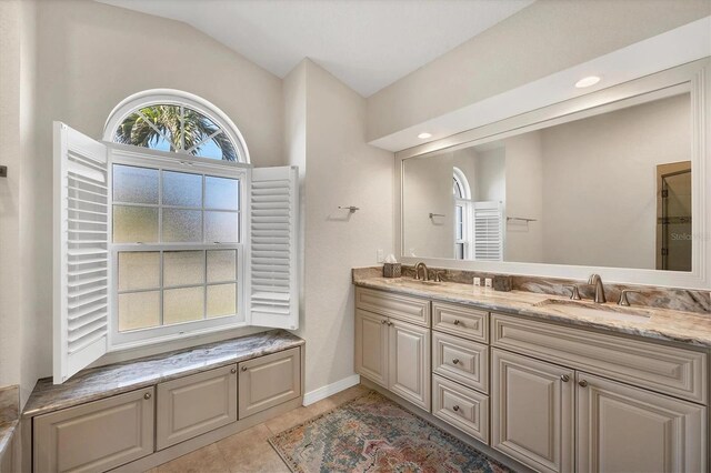 3520 Caya Largo Ct, Punta Gorda, FL 33950 - full bath with vaulted ceiling, double vanity, and baseboards