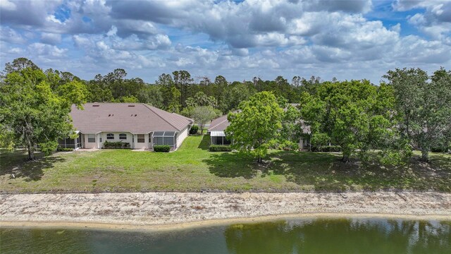 rear view of house featuring a lawn and a water view