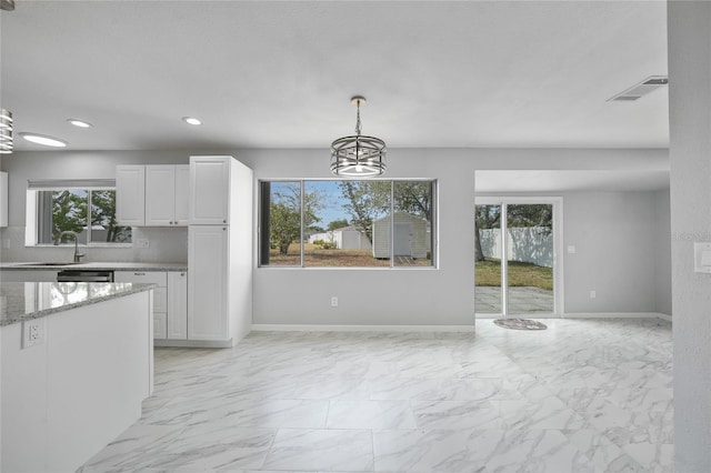 unfurnished dining area with recessed lighting, a sink, marble finish floor, and baseboards