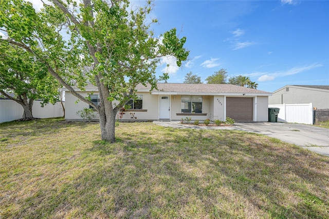 ranch-style home with a garage, fence, a front yard, stucco siding, and concrete driveway