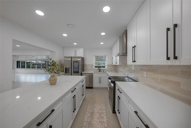 27385 Voyageur Dr, Punta Gorda, FL 33983 - kitchen with stainless steel appliances, wall chimney exhaust hood, a sink, white cabinetry, and recessed lighting