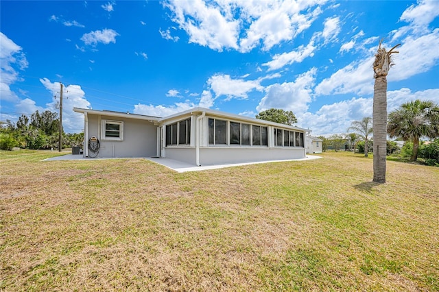 27385 Voyageur Dr, Punta Gorda, FL 33983 - back of house with a yard, a patio, stucco siding, and a sunroom