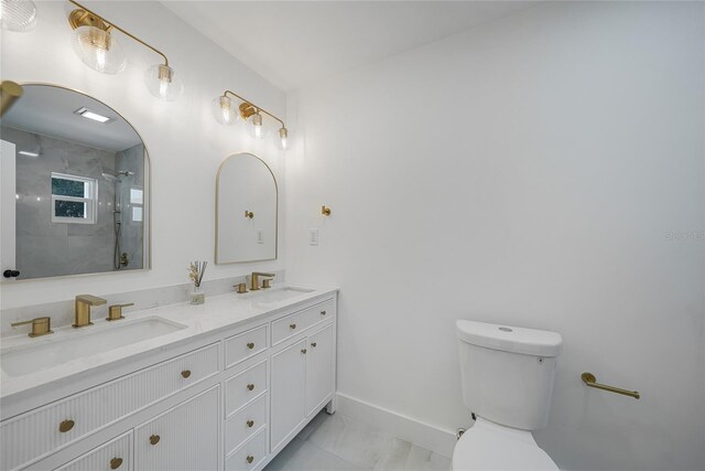 27385 Voyageur Dr, Punta Gorda, FL 33983 - bathroom with toilet, marble look tiles, baseboards, a tile shower, and double vanity