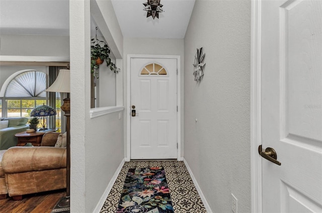 entryway with baseboards and a textured wall