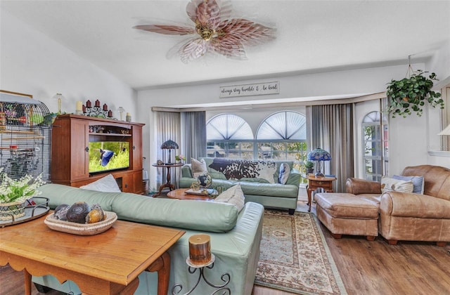 living room with a ceiling fan, wood finished floors, and lofted ceiling