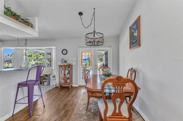 dining area with an inviting chandelier, baseboards, wood finished floors, and a wealth of natural light