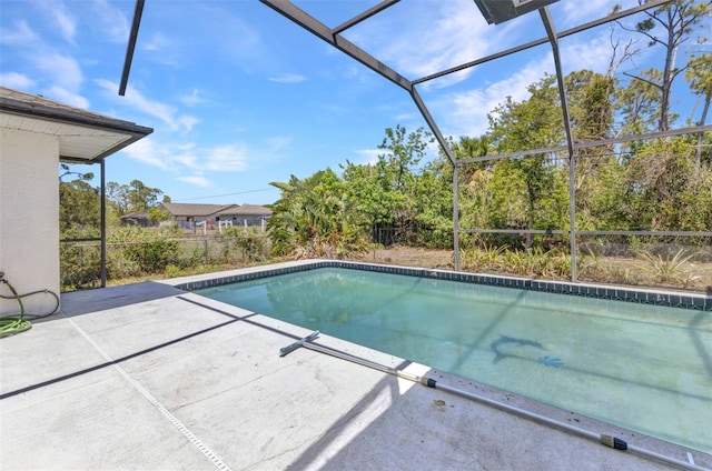 outdoor pool with a patio and glass enclosure
