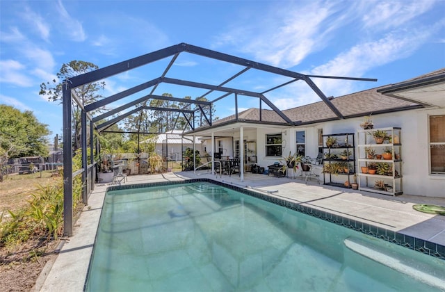 outdoor pool with a patio and glass enclosure