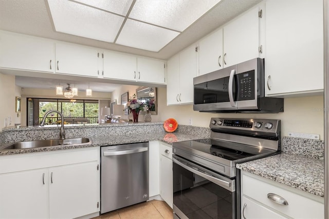 kitchen featuring white cabinetry, appliances with stainless steel finishes, a sink, and light tile patterned floors
