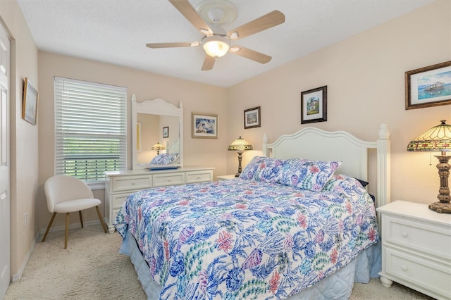 bedroom with baseboards, ceiling fan, and light carpet