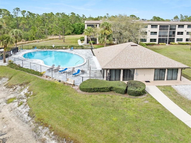 community pool featuring fence and a yard