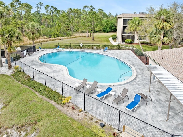 pool featuring a yard, a patio, and fence