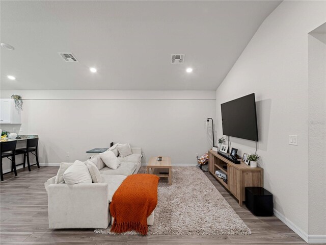 15579/15581 Chamberlain Blvd, Port Charlotte, FL 33953 - living room with light wood-style floors, baseboards, lofted ceiling, and visible vents