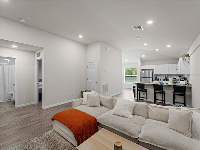 15579/15581 Chamberlain Blvd, Port Charlotte, FL 33953 - living room with recessed lighting, baseboards, vaulted ceiling, and light wood-style floors