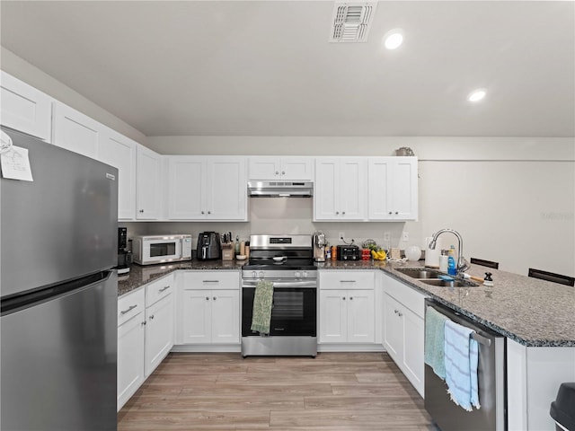 15579/15581 Chamberlain Blvd, Port Charlotte, FL 33953 - kitchen with appliances with stainless steel finishes, a sink, a peninsula, under cabinet range hood, and visible vents