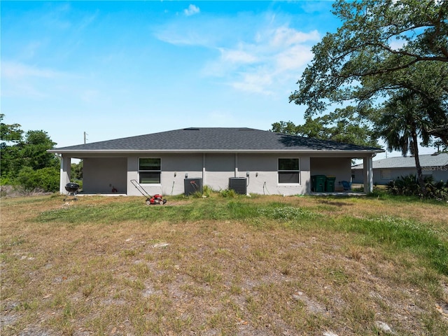 15579/15581 Chamberlain Blvd, Port Charlotte, FL 33953 - back of property featuring a lawn, central AC unit, and stucco siding