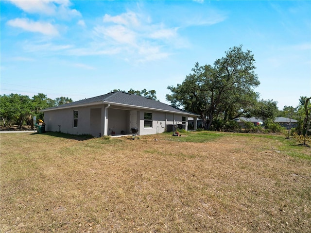 15579/15581 Chamberlain Blvd, Port Charlotte, FL 33953 - back of house featuring a lawn and stucco siding
