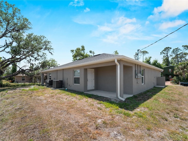 17190/17192 Nixon Ave, Port Charlotte, FL 33948 - rear view of property with stucco siding, a yard, central AC, and a patio area
