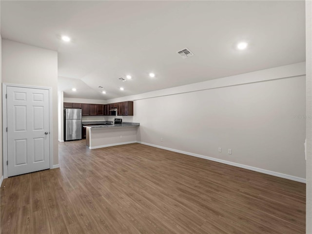 17190/17192 Nixon Ave, Port Charlotte, FL 33948 - unfurnished living room with baseboards, visible vents, wood finished floors, and vaulted ceiling
